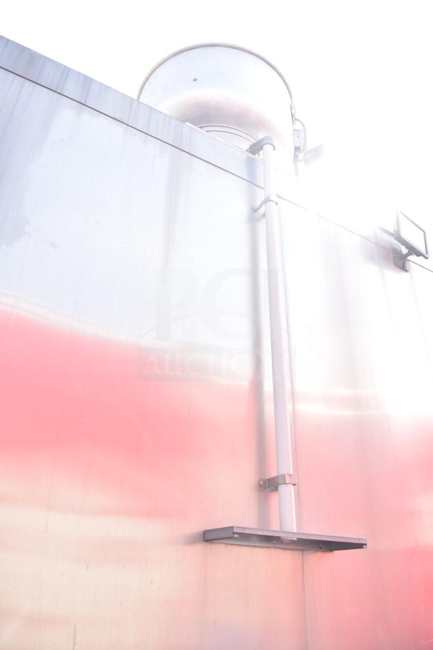 Alt text: Stainless steel exterior of a Texino food trailer, showing part of a CaptiveAire hood system and piping.