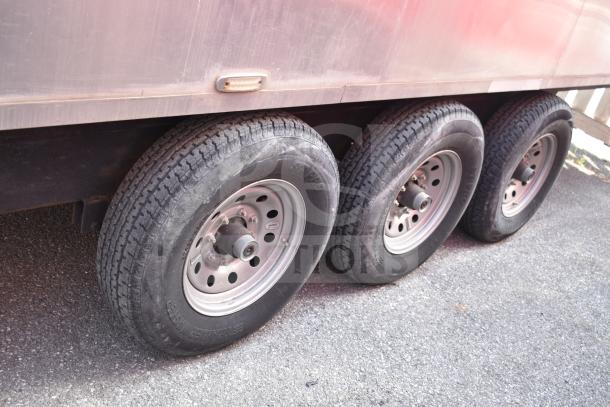 Triple-axle of Texino 2021 28ft commercial food trailer, featuring durable tires and sturdy rims.