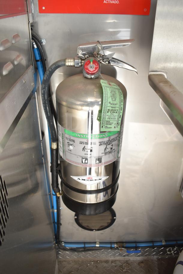 Silver fire suppression system inside 2021 Texino food trailer, featuring Amerex label and instructional tags.