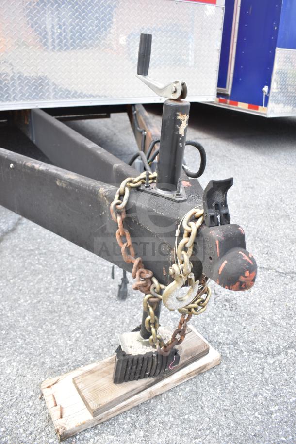Trailer hitch of 2021 Rock Solid Cargo 28ft food trailer, secured with chains; visible diamond plate pattern.