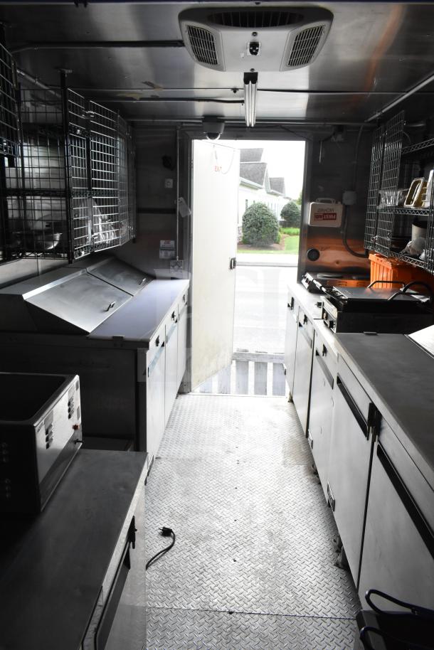 Food trailer interior with dual Pitco gas fryers, CaptiveAire hood, full Arctic Air refrigeration, and Daikin mini-split system.