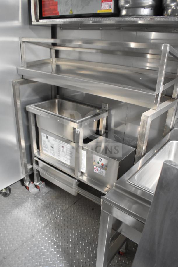 Stainless steel interior of 2021 Texino food trailer with shelving and equipment setup, including visible control panel and instructions.