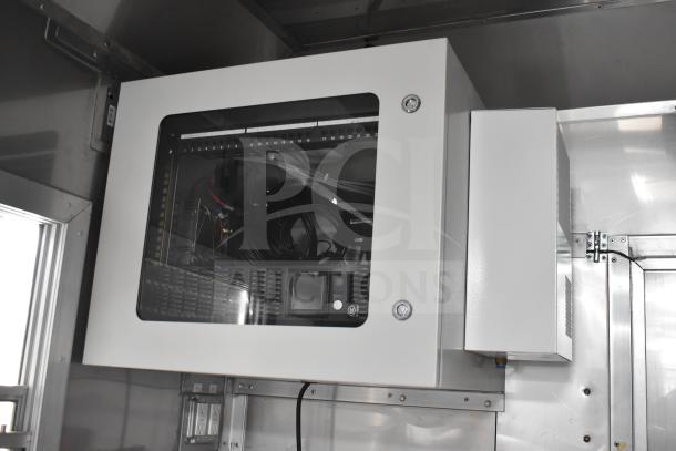 Interior view of a 2021 Texino 28ft food trailer showing an electrical cabinet with a clear glass front, cables, and control panel.