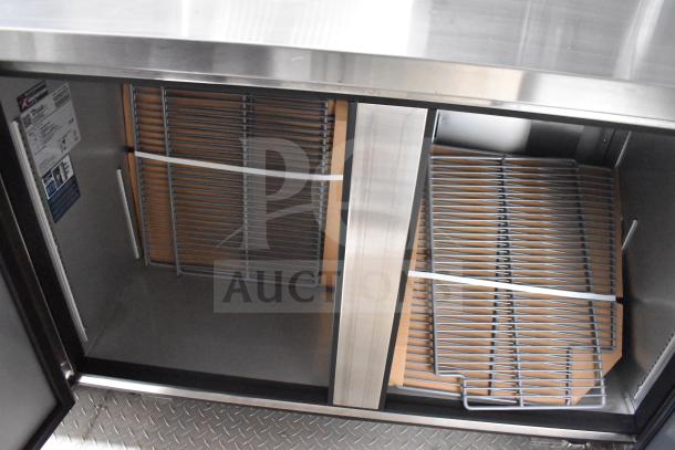 Interior view of Texino 28ft food trailer, showing True refrigeration compartments with shelving and visible serial label.