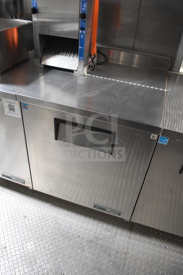 New 2021 Texino 28ft food trailer interior, featuring True refrigeration unit and stainless steel surfaces.