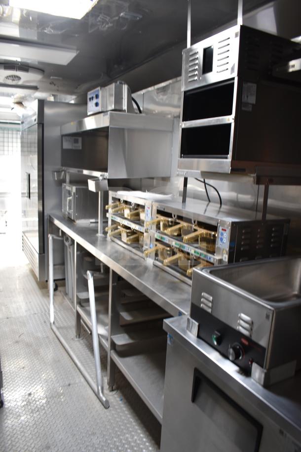 Interior of a 2021 Texino 28ft food trailer featuring CaptiveAire hood, Ultrafryer fryer, True refrigeration, and Winston CVap.