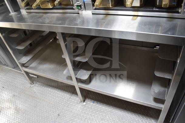 Stainless steel interior of a 2021 Texino food trailer, showcasing storage shelves and equipment placement.