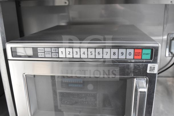 Stainless steel industrial microwave with numeric keypad and QR code, installed in Texino 2021 food trailer.
