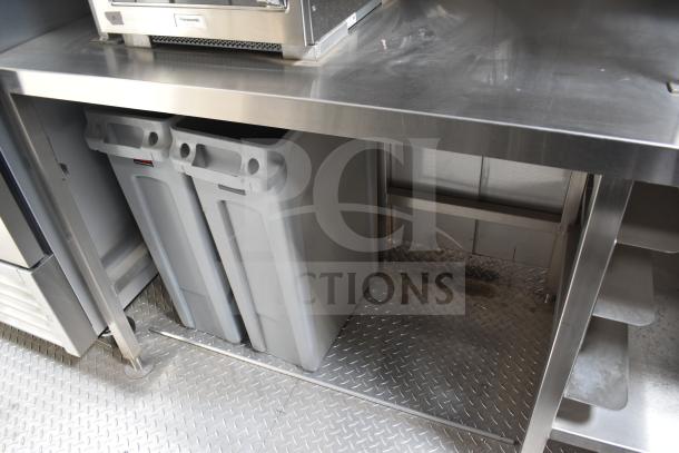Interior of 2021 Texino 28ft food trailer with stainless steel surfaces and storage bins.