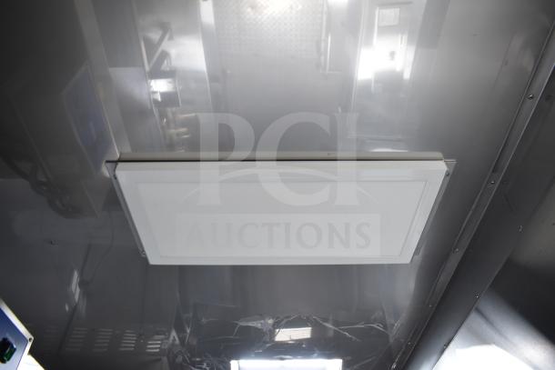 Inside view of 2021 Texino 28ft food trailer, showing CaptiveAire hood system. Clean stainless steel finish.