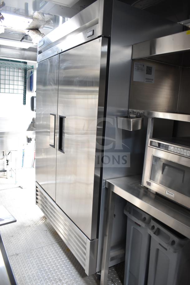 Texino 28ft commercial food trailer interior with stainless steel True refrigeration unit and commercial kitchen equipment.