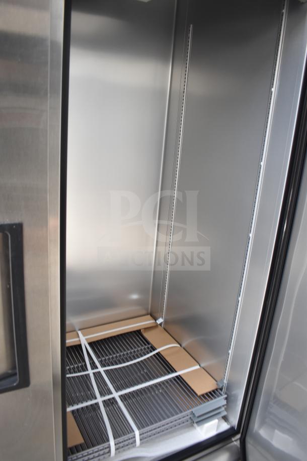 Interior view of a new 2021 Texino food trailer's stainless steel refrigeration unit, showing shelving and packaging materials.