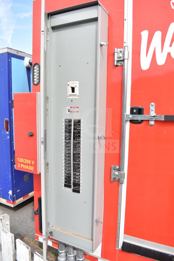 2021 Rock Solid Cargo 28ft food trailer, electrical panel open, 120/208V 3-phase label visible on red exterior.