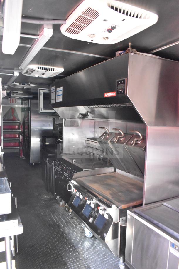 2021 Rock Solid Cargo 28ft food trailer interior; features Henny Penny fryer, Taylor griddle, CaptiveAire hood, refrigeration units.