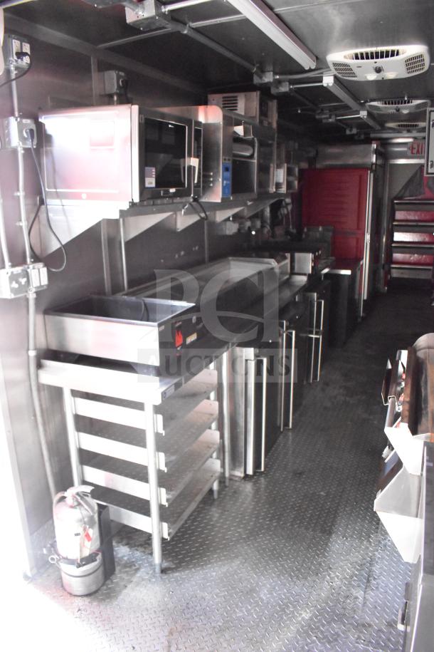 2021 Rock Solid Cargo 28ft food trailer interior, featuring a Henny Penny fryer, Taylor griddle, CaptiveAire hood, full refrigeration.
