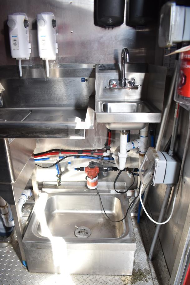 2021 Rock Solid Cargo 28ft food trailer sink area, featuring stainless steel sink, faucet, and visible plumbing.