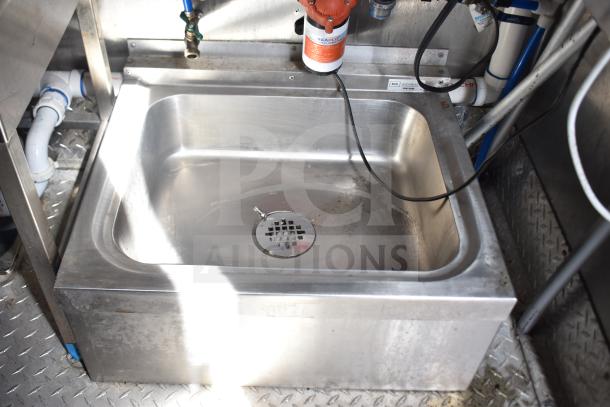 Stainless steel sink inside the 2021 Rock Solid Cargo food trailer, featuring plumbing and diamond plate flooring.