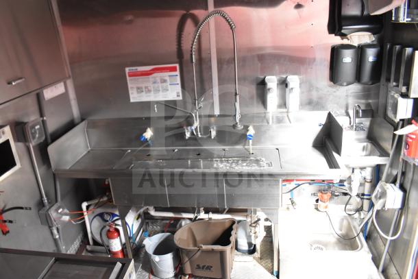 2021 Rock Solid Cargo 28ft food trailer interior with stainless steel sink, industrial faucet, and sanitation supplies.