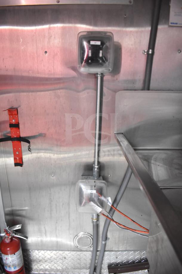 Interior of 2021 Rock Solid Cargo 28ft food trailer showing stainless steel walls, electrical boxes, and visible wiring.