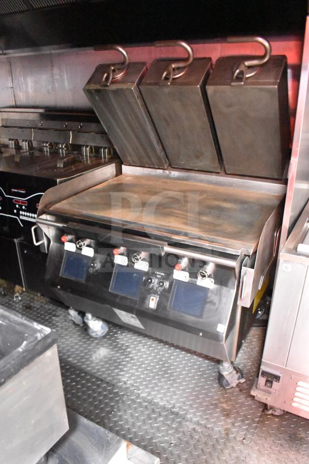 2021 Rock Solid Cargo 28ft food trailer interior with Taylor Clamshell Griddle, CaptiveAire hood, and non-slip flooring.