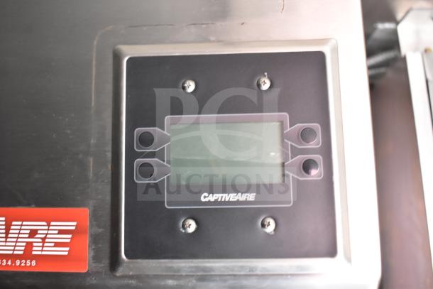 CaptiveAire control panel; stainless steel surface with a digital screen, screws, and logo. Part of commercial food trailer equipment.