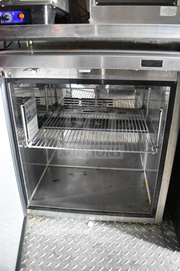 Interior view of the 2021 Rock Solid Cargo food trailer's refrigeration unit, showing stainless steel shelves and temperature control.