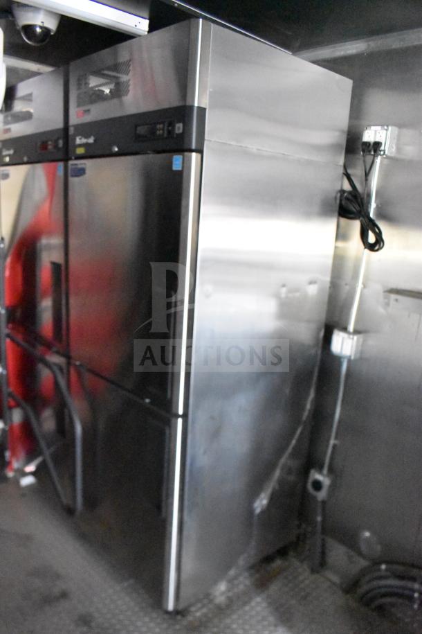 Interior of a 2021 Rock Solid Cargo 28ft food trailer showing commercial refrigeration unit. Stainless steel finish, electric wiring visible.