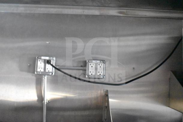 Interior of Rock Solid Cargo 28ft food trailer showing electrical outlets and wiring on a metallic wall surface.