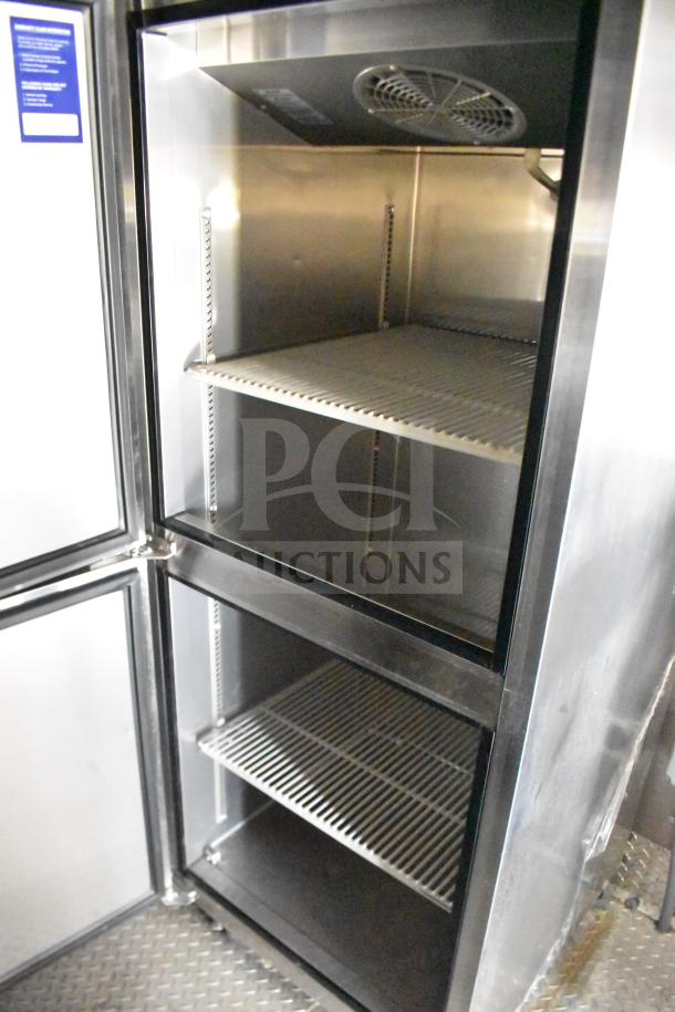 Stainless steel interior of a refrigeration unit with two wire shelves, part of a 2021 Rock Solid Cargo food trailer.