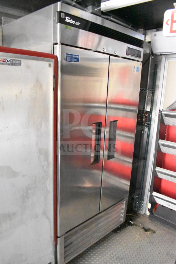 Stainless steel Turbo Air commercial refrigerator in 2021 Rock Solid Cargo 28ft food trailer, featuring dual doors and sleek design.
