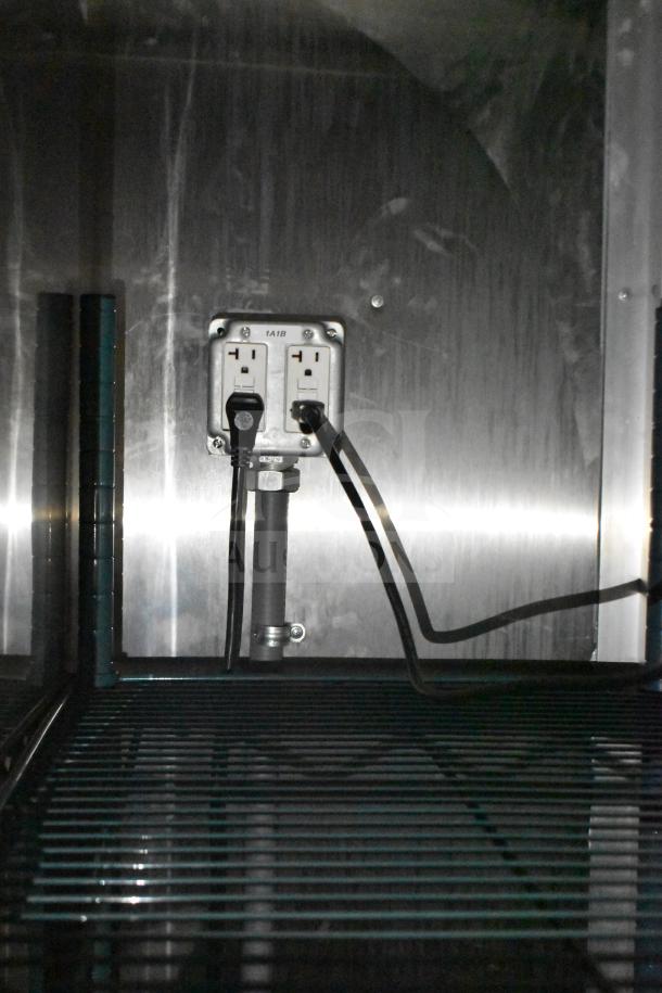 Interior of 2021 Rock Solid Cargo 28ft food trailer featuring electric outlets and shelving.