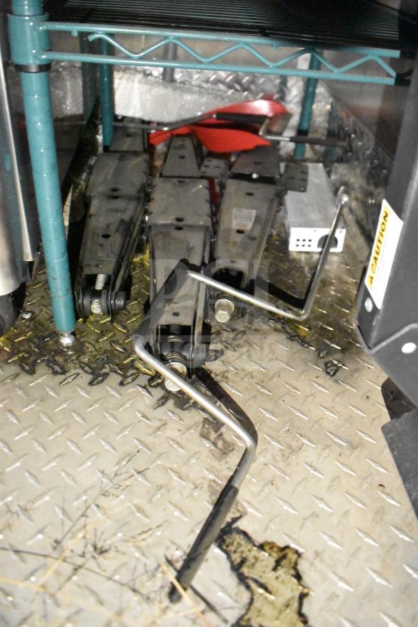 Storage area inside 2021 Rock Solid Cargo 28ft Food Trailer with tools on diamond plate flooring.