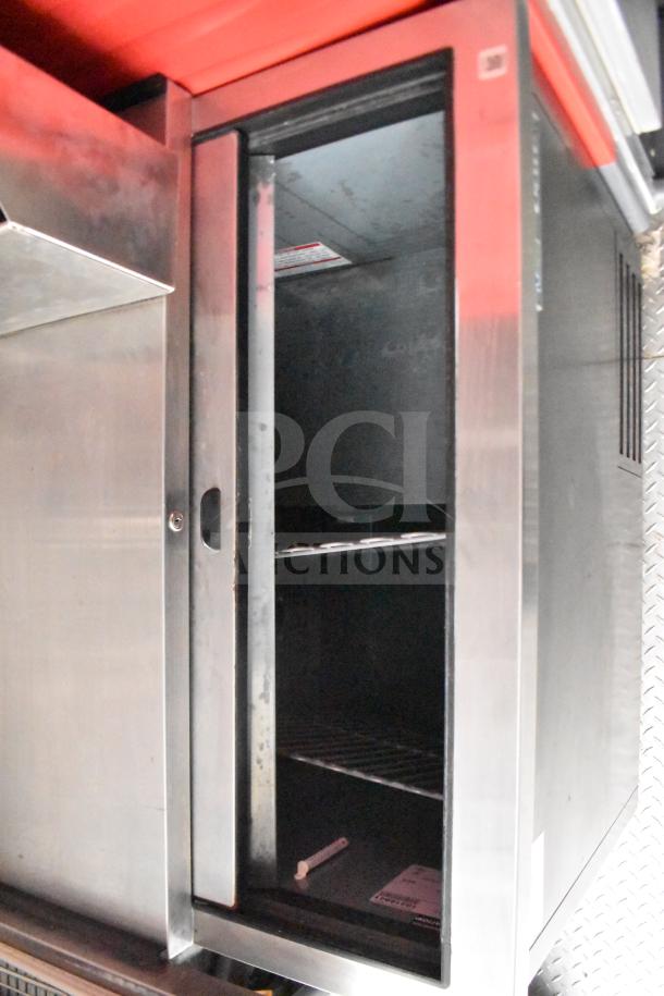 Stainless steel interior of a 2021 Rock Solid Cargo 28ft food trailer. Features shelving and reflective surfaces.