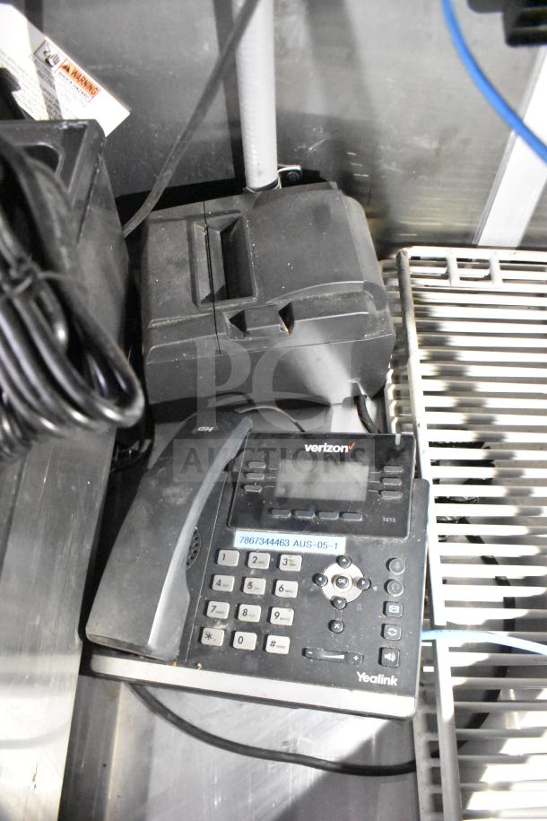 Office phone setup within a commercial food trailer, displaying Verizon branding and a Yealink model.