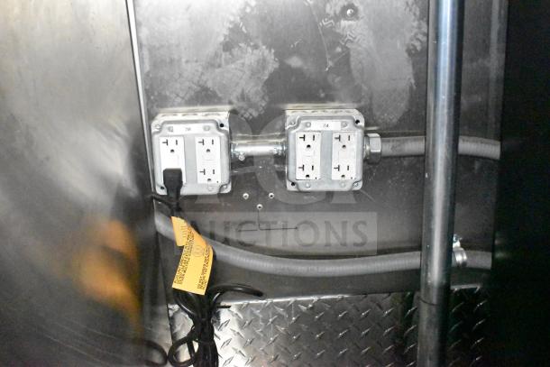 Outlets in Rock Solid Cargo 28ft food trailer with visible wiring and caution tag, indicating electrical equipment capability.