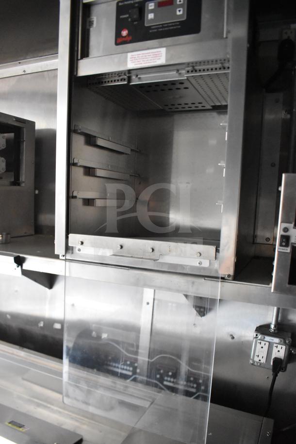 Interior view of a 2021 Rock Solid Cargo 28ft food trailer. Features visible include stainless appliances and control panels.