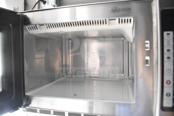 Interior view of a clean stainless steel commercial microwave inside a 2021 Rock Solid Cargo 28ft food trailer.