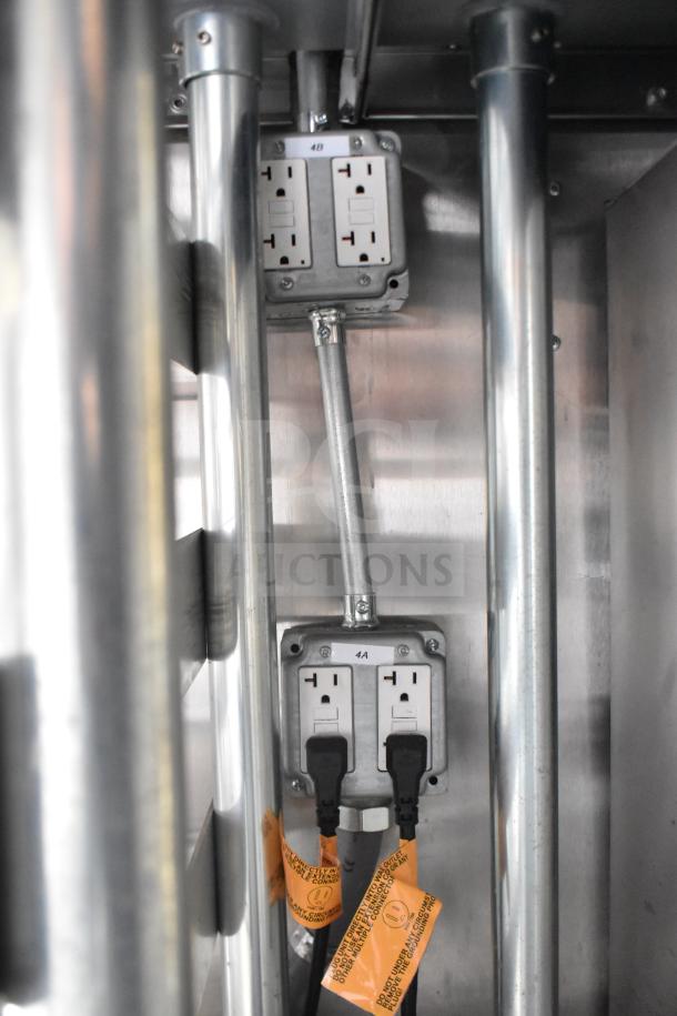 Electrical outlets inside the 2021 Rock Solid Cargo 28ft food trailer with protective tags, part of its commercial kitchen setup.