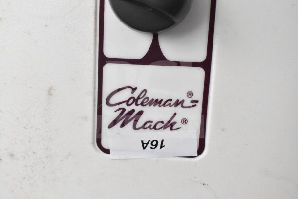 "Close-up of Coleman-Mach label on a white surface, featuring black control knob. Label reads 'Coleman-Mach.'"
