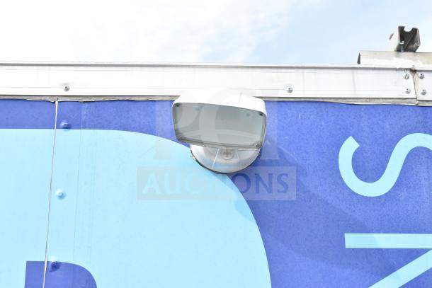 Exterior detail of NBRHD Kitchens Ghost Kitchen Food Trailer, showing part of the trailer's branding and an attached light fixture.