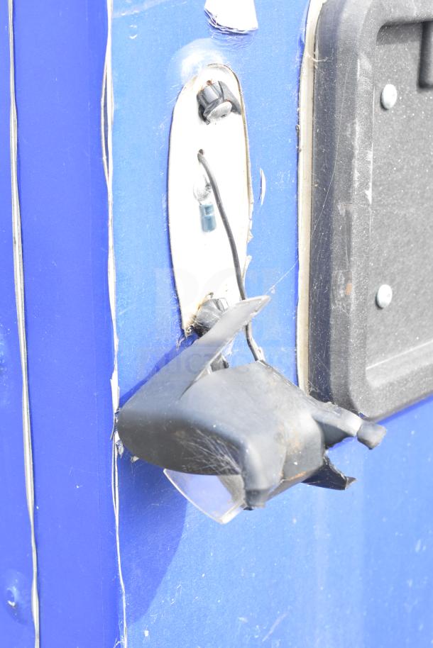 Blue food trailer with wear around a handle or fixture, highlighting a damaged black component. Part of a Ghost Kitchen setup.