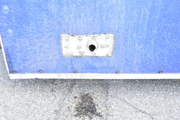 Exterior view of the NBRHD Kitchens Ghost Kitchen food trailer, blue panel with a metallic fixture.