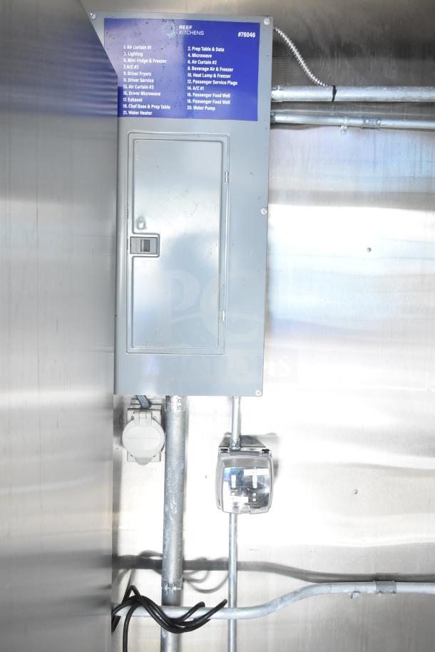 NBRHD Kitchens food trailer with electrical panel and wiring, featuring visible labels for equipment like fryers and refrigeration.