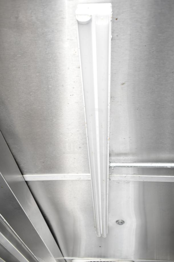Interior view of NBRHD Kitchens Ghost Kitchen trailer ceiling, featuring a mounted fluorescent light fixture.