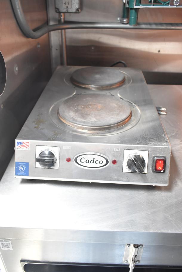 Cadco electric hot plate in NBRHD Kitchens trailer, dual burners, control knobs, used condition, stainless steel surface.