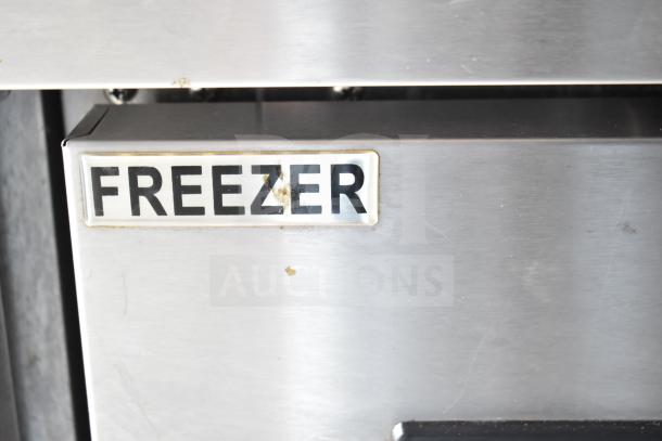Stainless steel freezer section of NBRHD Kitchens Ghost Kitchen food trailer, featuring a visible "FREEZER" label.