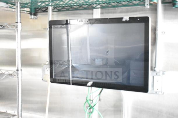 NBRHD Kitchens Ghost Kitchen food trailer interior, showcasing mounted screen, metal shelving, and electrical setup.