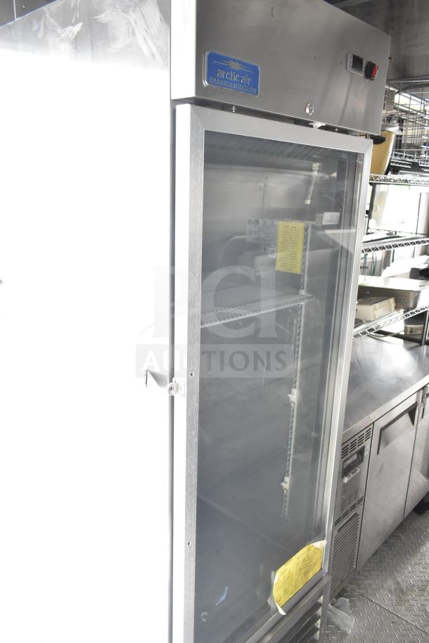 "Arctic Air commercial refrigerator in NBRHD Kitchens Ghost Kitchen food trailer, featuring a CaptiveAire hood and stainless steel shelves."