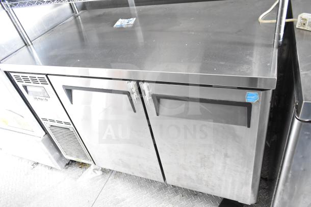NBRHD Kitchens food trailer interior featuring Arctic Air refrigeration unit with stainless steel finish, showing minor wear.