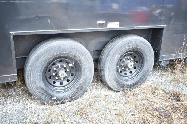 2020 Southern Dimensions Group 8.5' x 20' all-black trailer, tandem axle, shown on gravel, featuring Navi Trac tires.